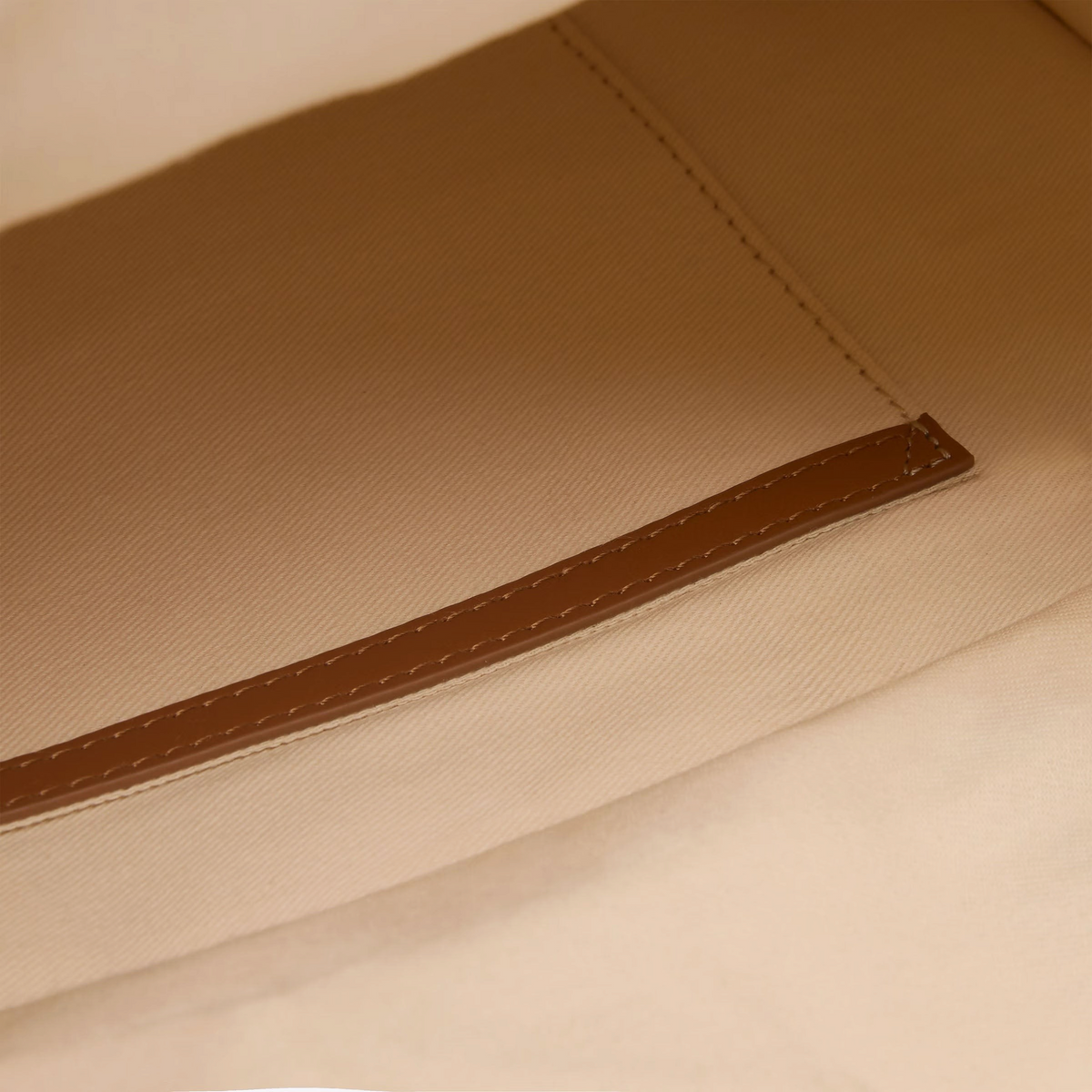 The Copper Shed Caprice Bag interior featuring beige cotton fabric lining and brown bovine leather trim detail.
