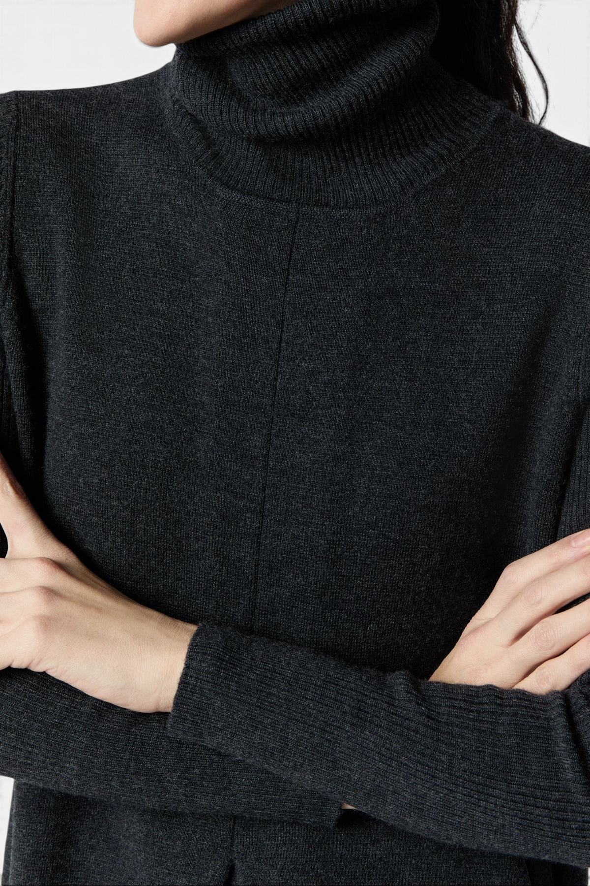 The Copper Shed Fosette sweater dress in charcoal merino wool with a ribbed funnel neck and center front pleat.
