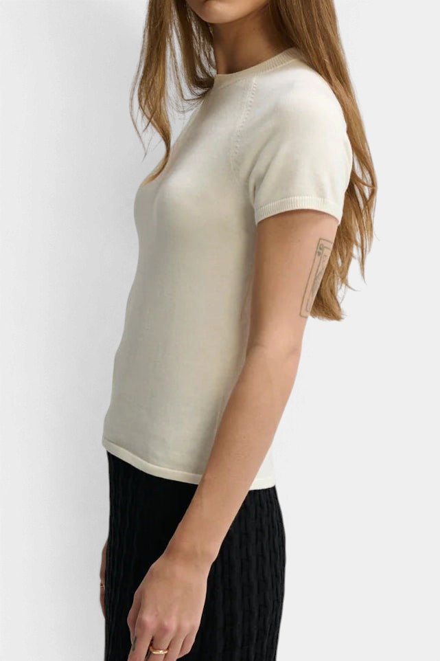The Copper Shed cream cotton-silk blend baby tee with raglan sleeves and ribbed crew neck worn by a model