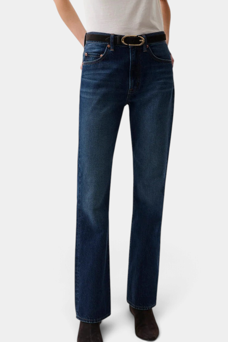 The Copper Shed Dakota high rise bootcut jeans in dark indigo denim worn by a model with a black belt