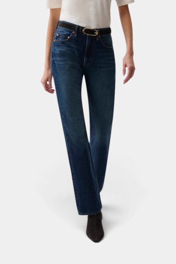 The Copper Shed Dakota high rise bootcut jeans in dark indigo denim worn with a black belt and dark boots.