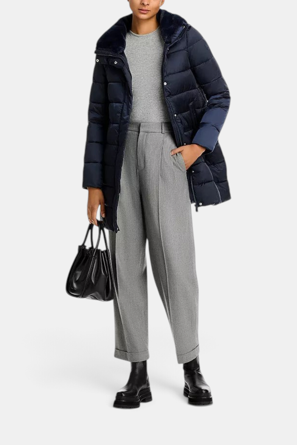 The Copper Shed Dalea navy puffer coat with channel quilting and a faux-fur stand collar worn over grey trousers.