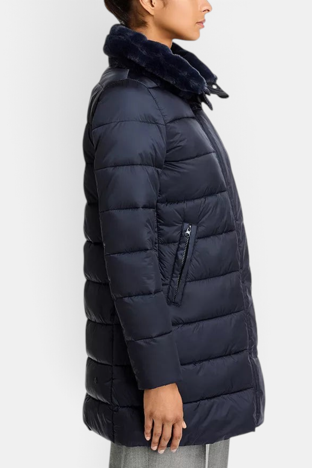 The Copper Shed Dalea navy puffer coat with channel quilting, faux-fur stand collar, and zip pockets on a model.