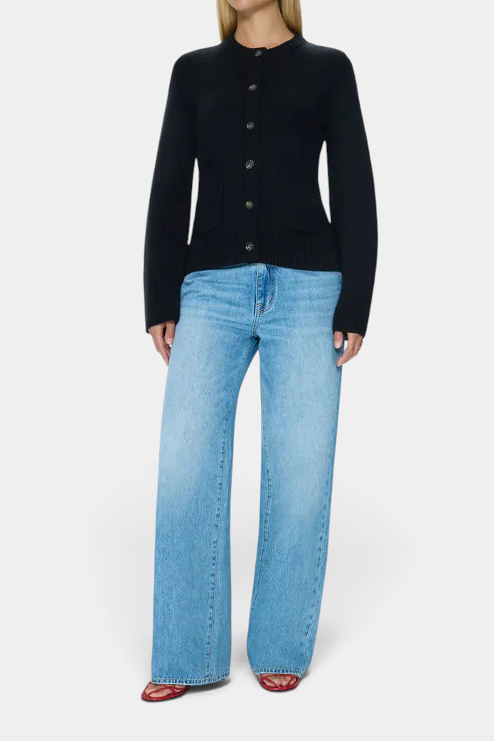 The Copper Shed Dani black button-front knit cardigan with a cinched waist, worn with light wash wide-leg jeans.