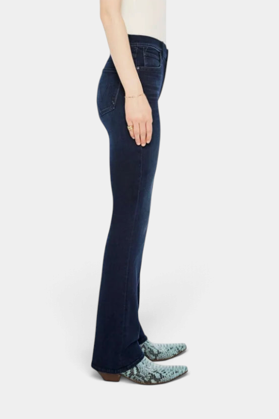 The Copper Shed mid-rise dark blue stretch denim flared jeans with clean hem, side view on model