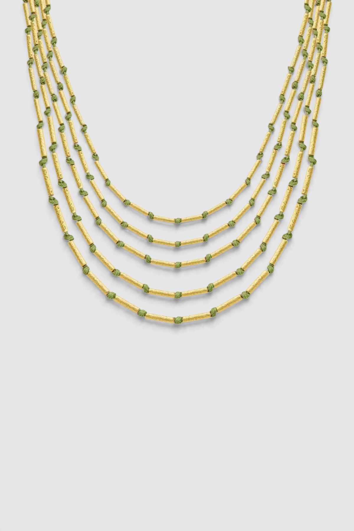 The Copper Shed Devitra multi-strand necklace with 18k gold plated cylinder beads and green string accents.