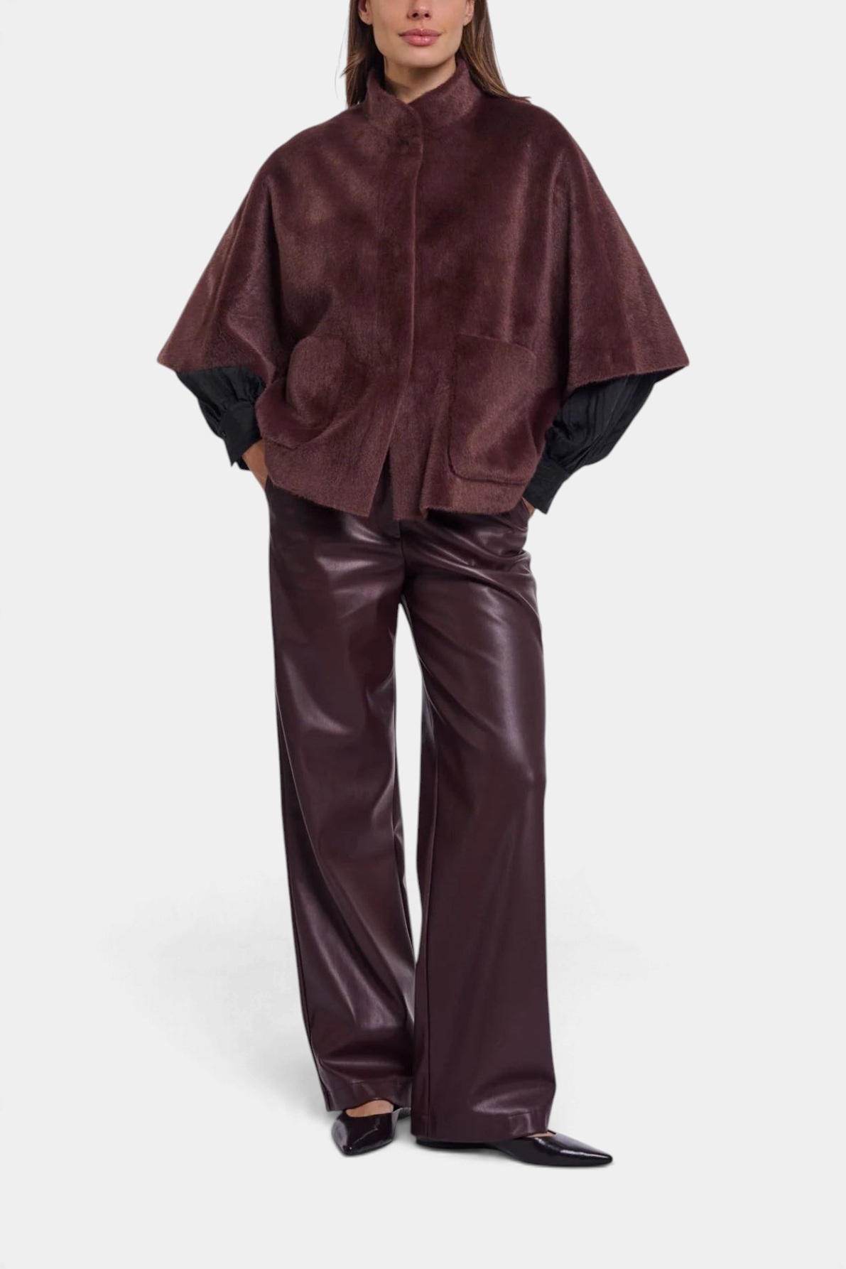 The Copper Shed Dewi cape in dark brown faux fur with a button-up front and relaxed silhouette on a model