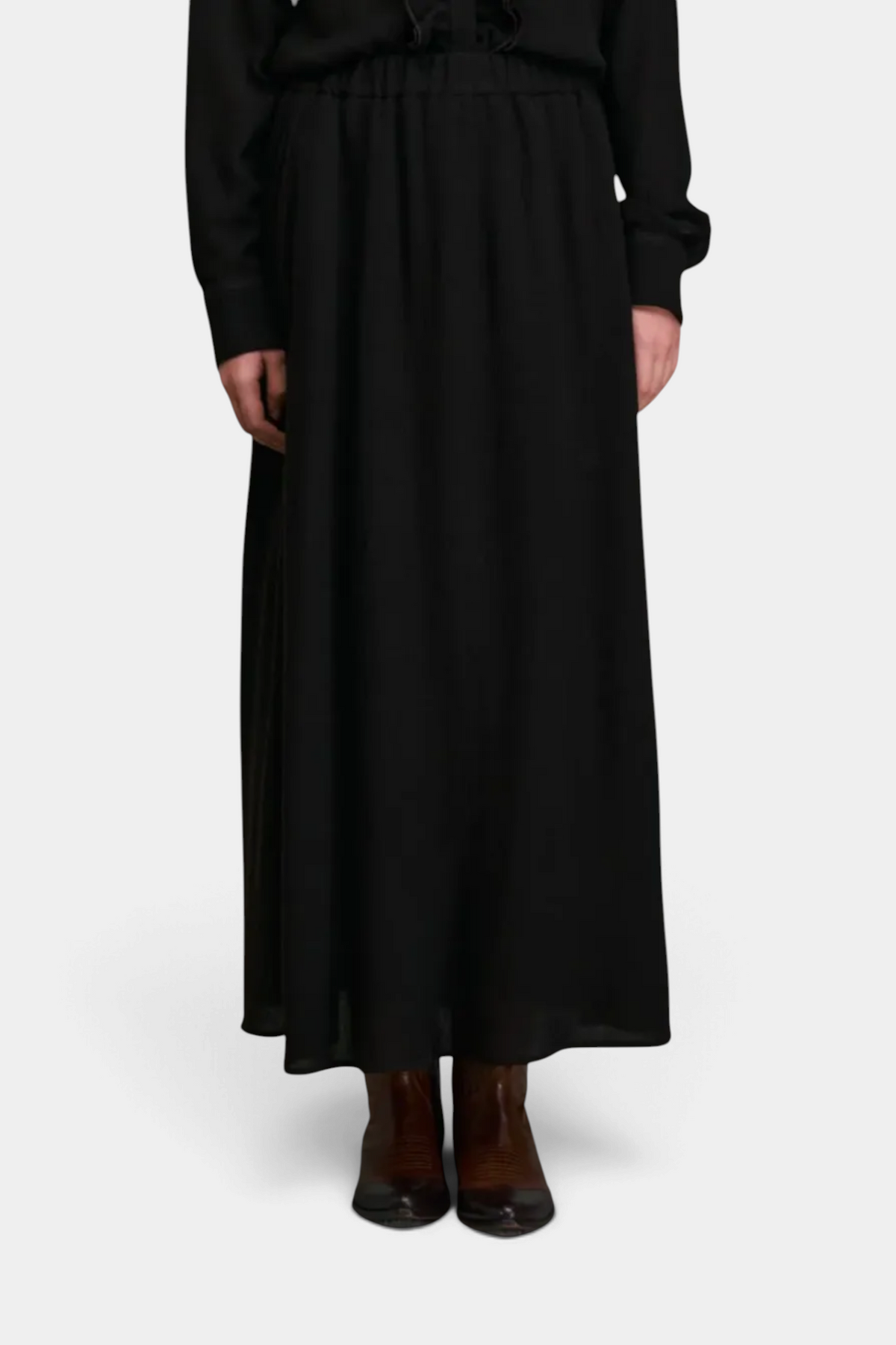 The Copper Shed Diega Jabo black maxi skirt with an elasticated waistband worn with brown leather boots