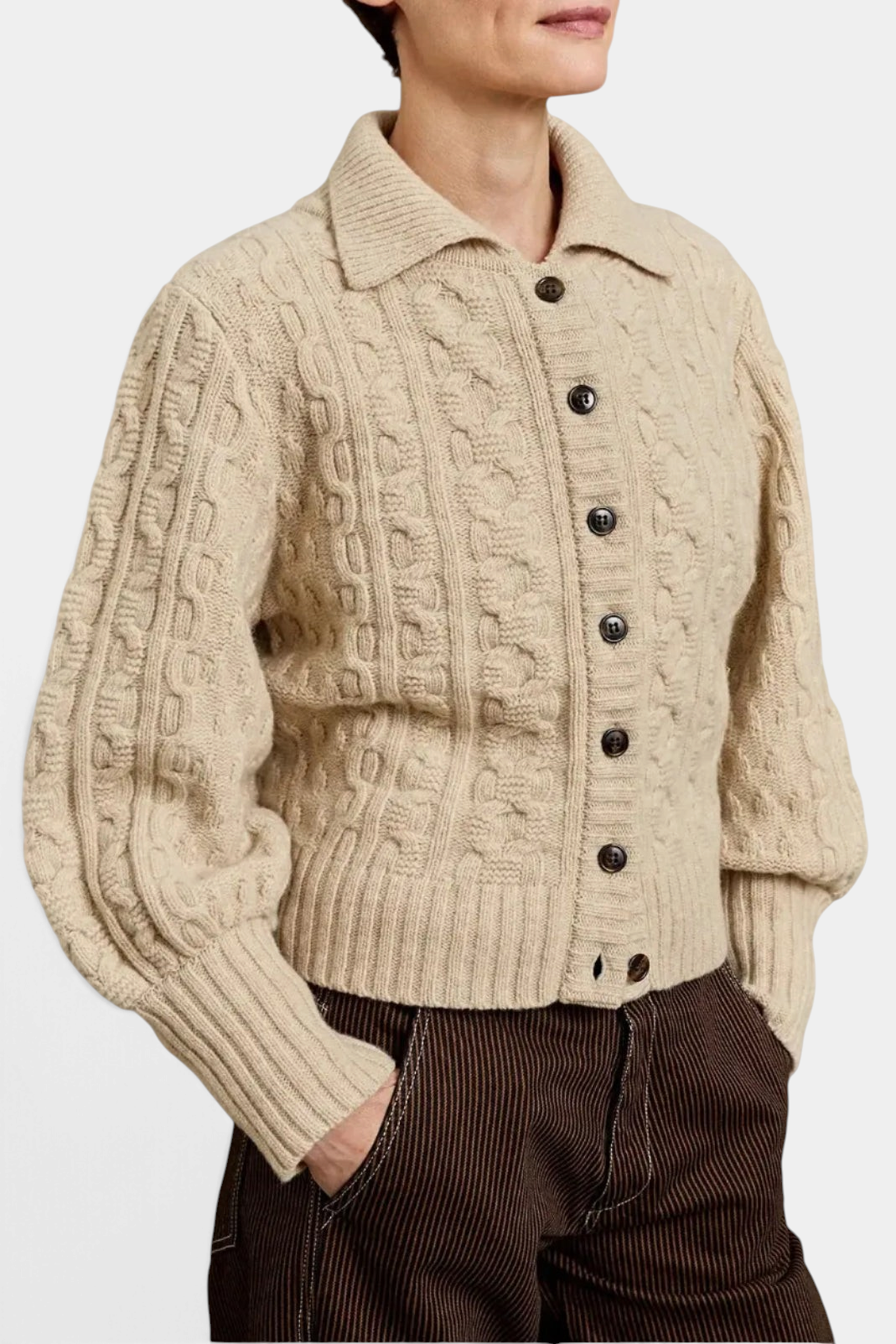 The Copper Shed ecru wool cable knit cardigan with a collared neckline and button-up front worn by a model.