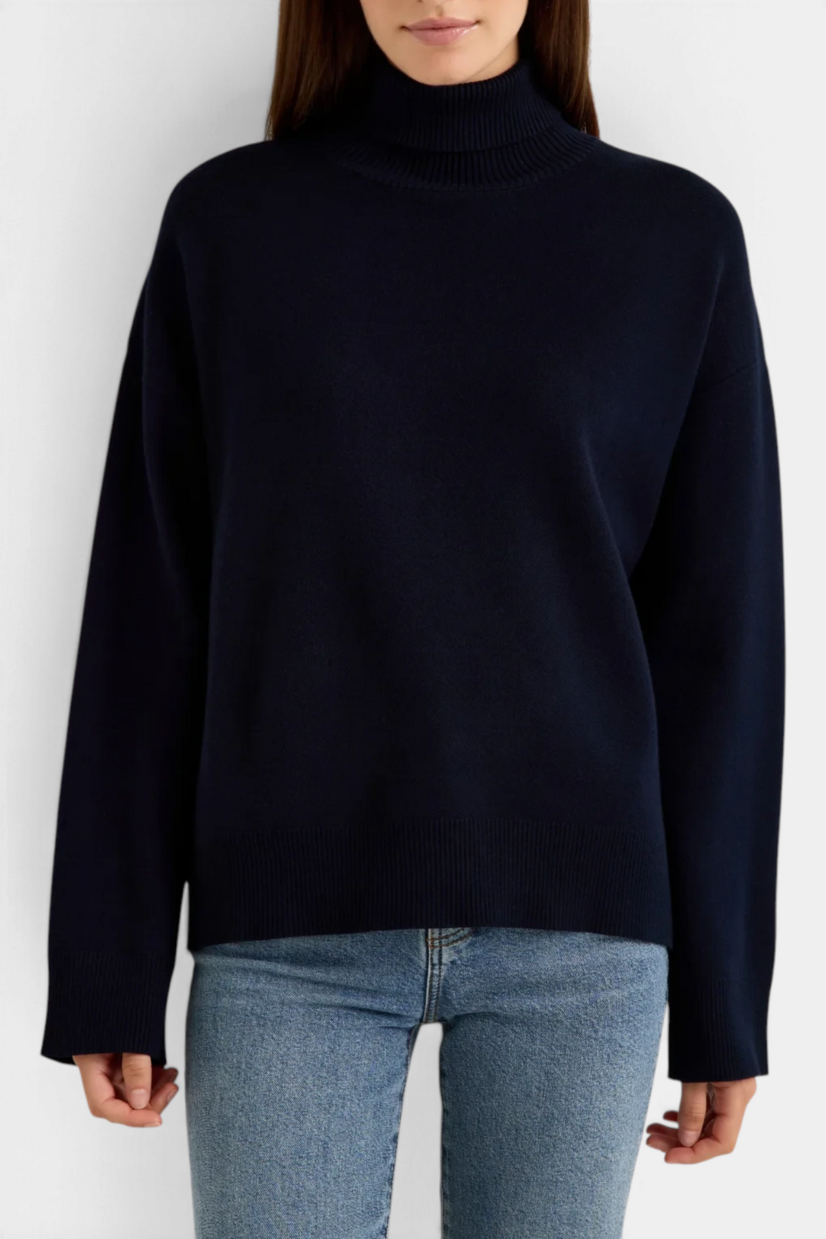The Copper Shed Emmy sweater in deep navy with a mock neck and relaxed boxy fit worn with blue jeans.