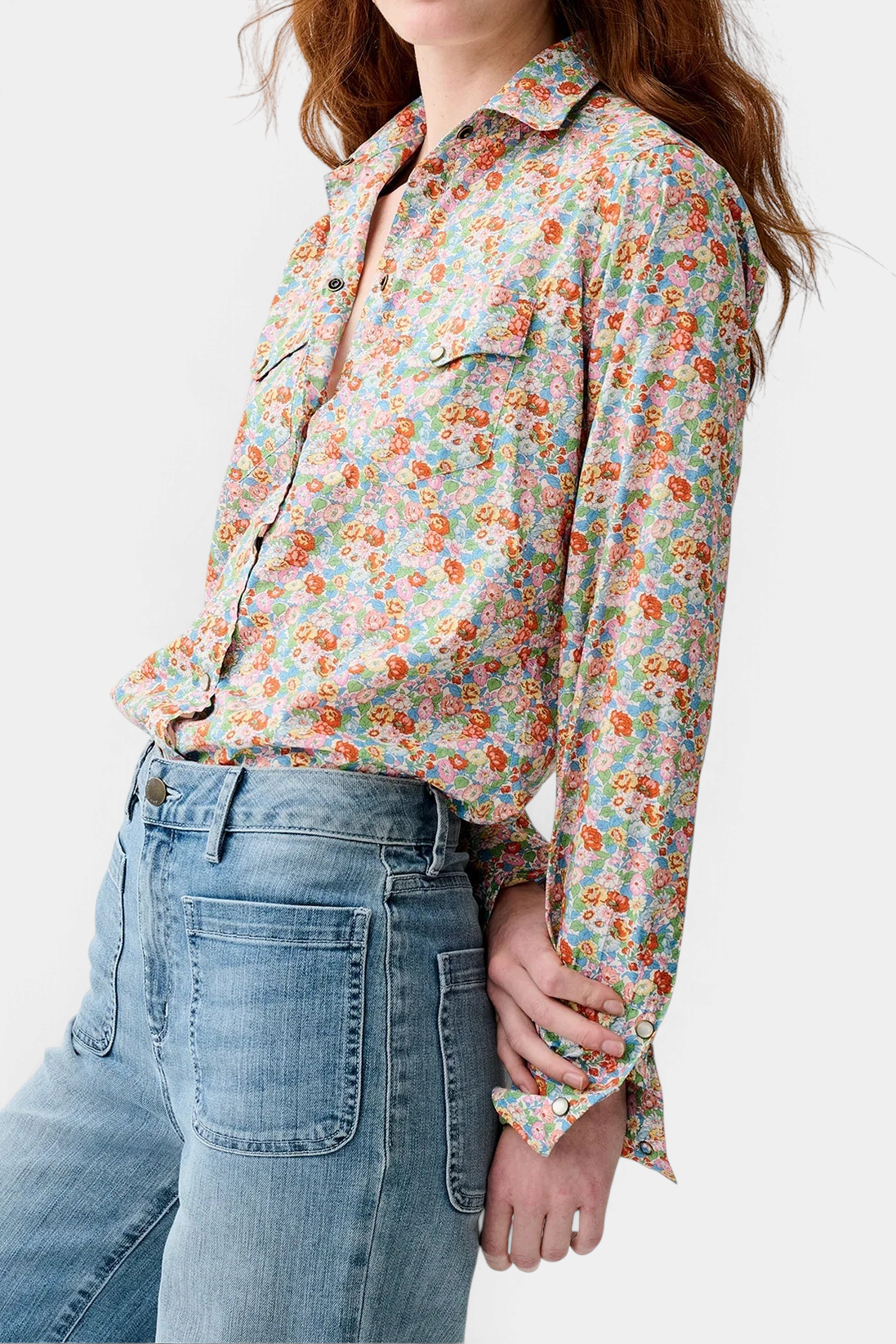 The Copper Shed floral print cotton Western shirt with pearl snaps and twin chest pockets worn by a woman.