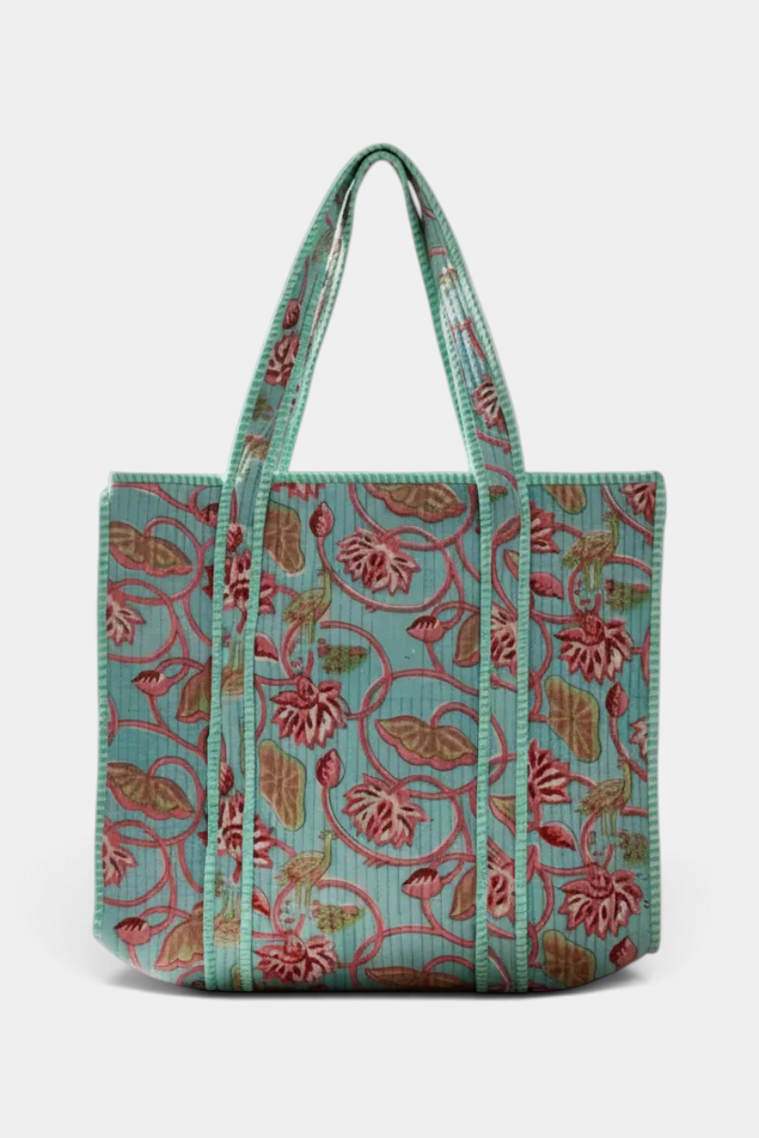 The Copper Shed reversible quilted cotton tote bag featuring a vibrant multicolor floral block print on teal fabric.