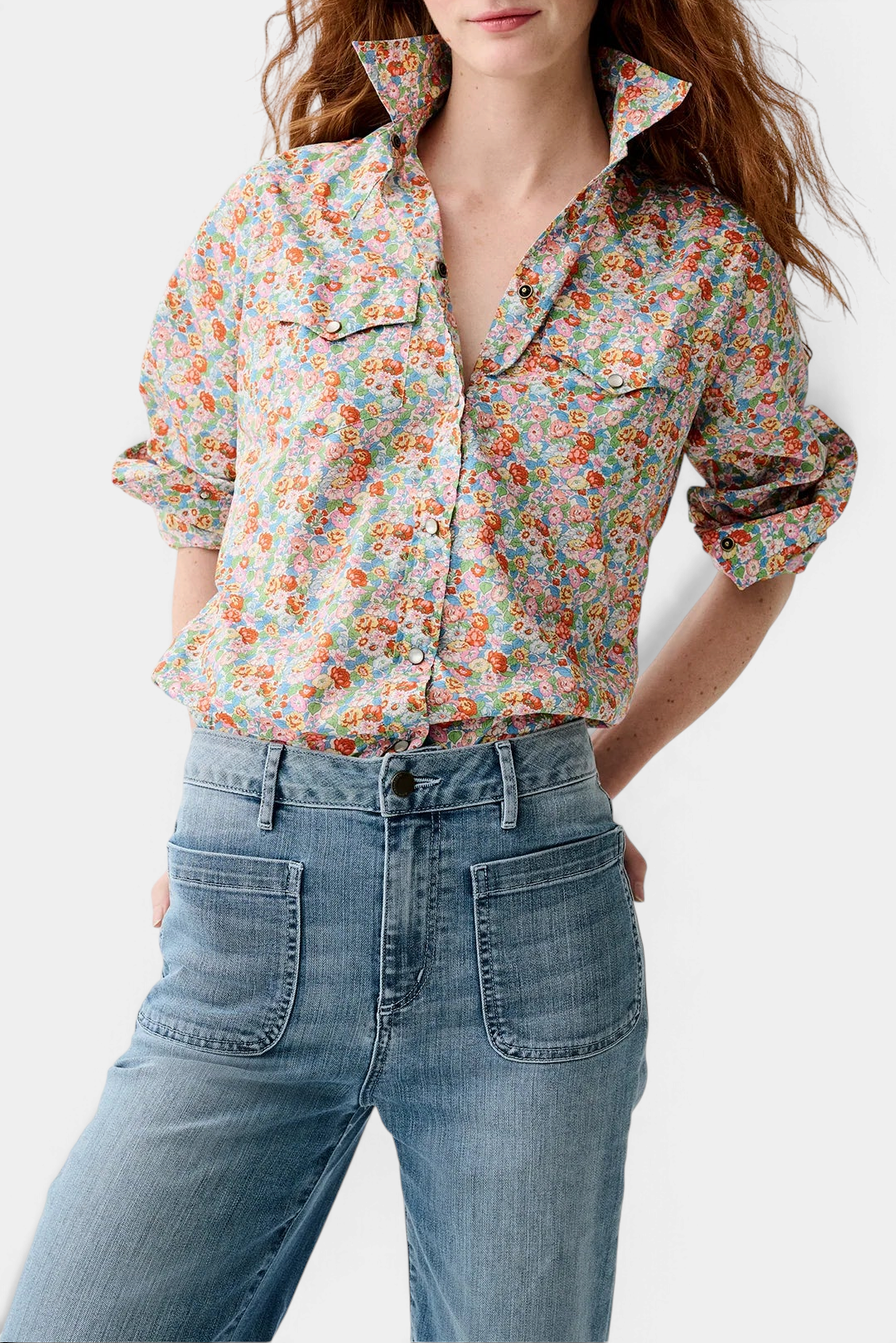 The Copper Shed floral Western shirt with pearl snaps and chest pockets worn tucked into blue denim jeans