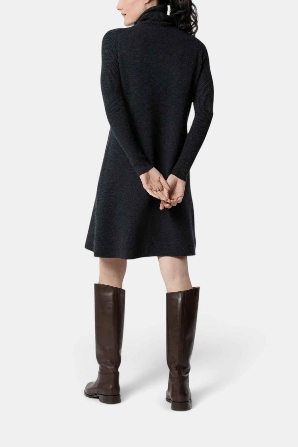 The Copper Shed Fosette sweater dress in charcoal merino wool with a funnel neck, worn with brown leather boots.