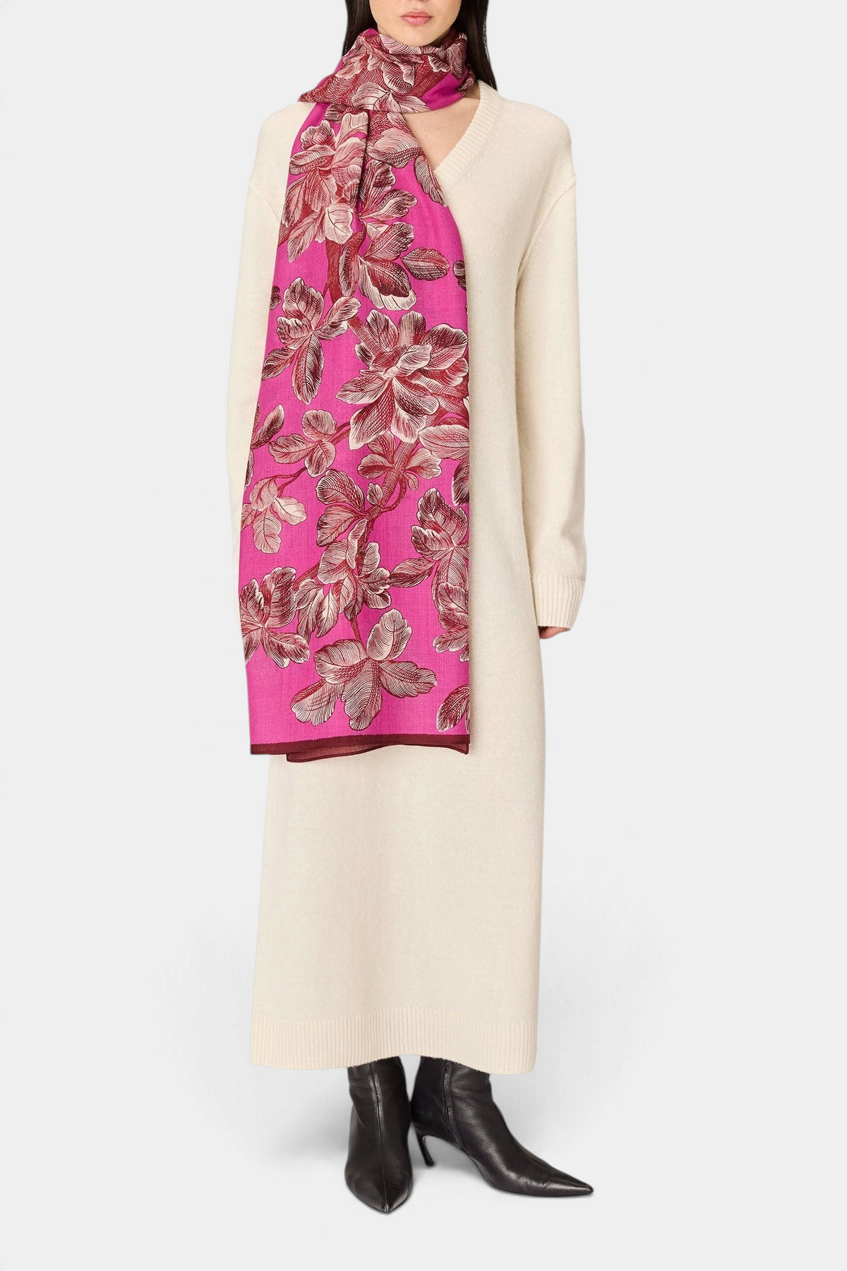 The Copper Shed Arboris fuchsia wool scarf with floral pattern worn by a model in a cream sweater dress