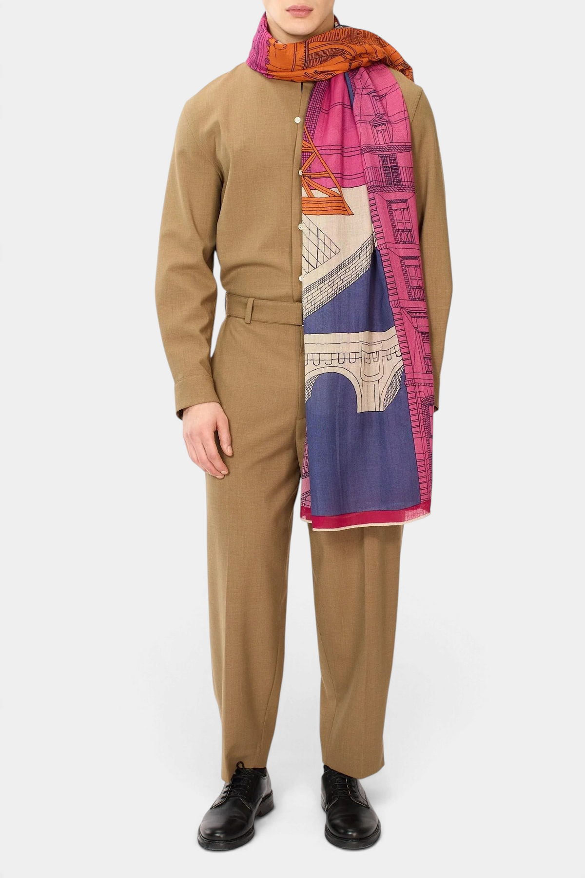 The Copper Shed Paris fuchsia wool scarf with architectural illustrations worn by a man in a tan outfit