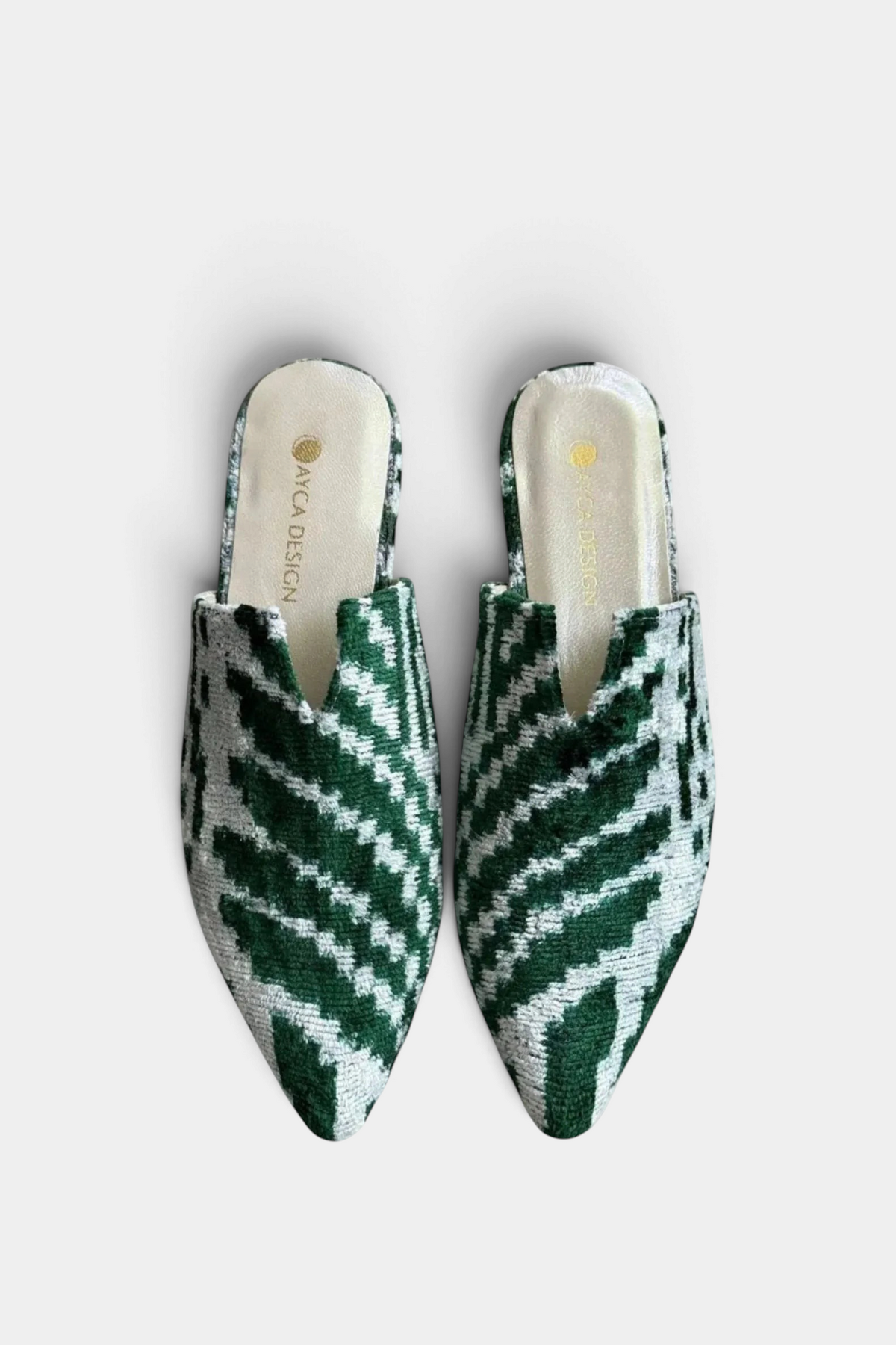 The Copper Shed silk velvet ikat pointed-toe slides in green and white with a leather-lined interior