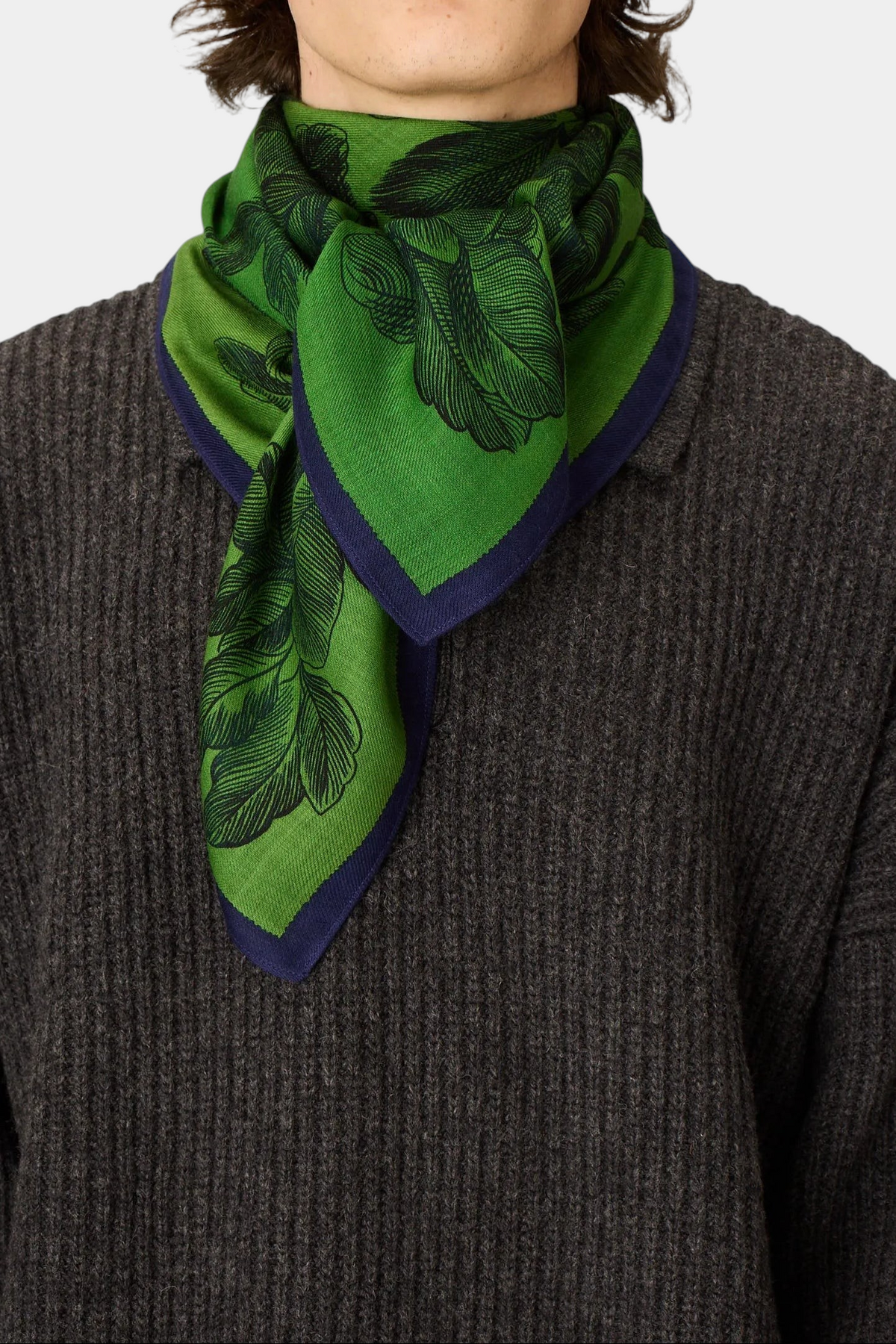 The Copper Shed Square 100 Arboris green wool scarf with black branch pattern worn around a model's neck