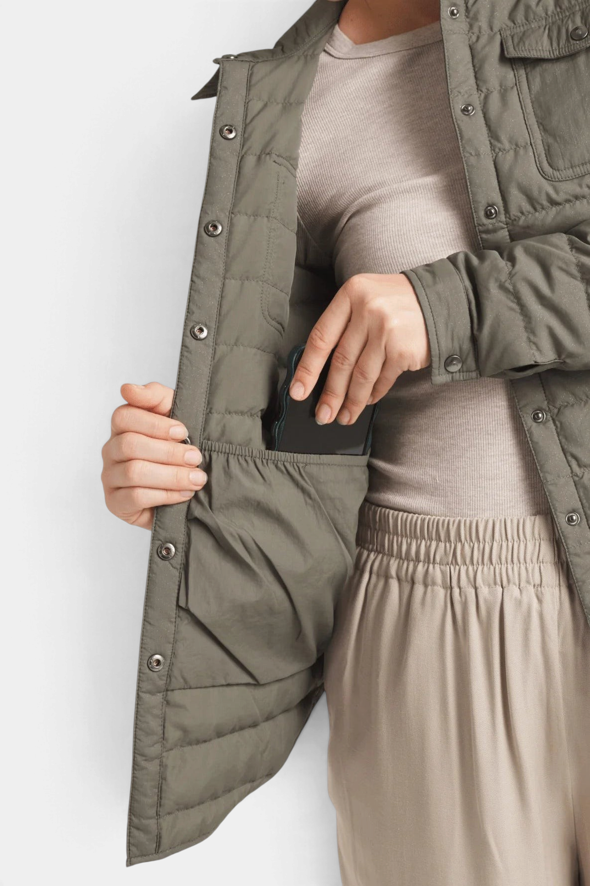 The Copper Shed Harrow matte olive green down shirt showing the spacious interior pocket with a phone inside