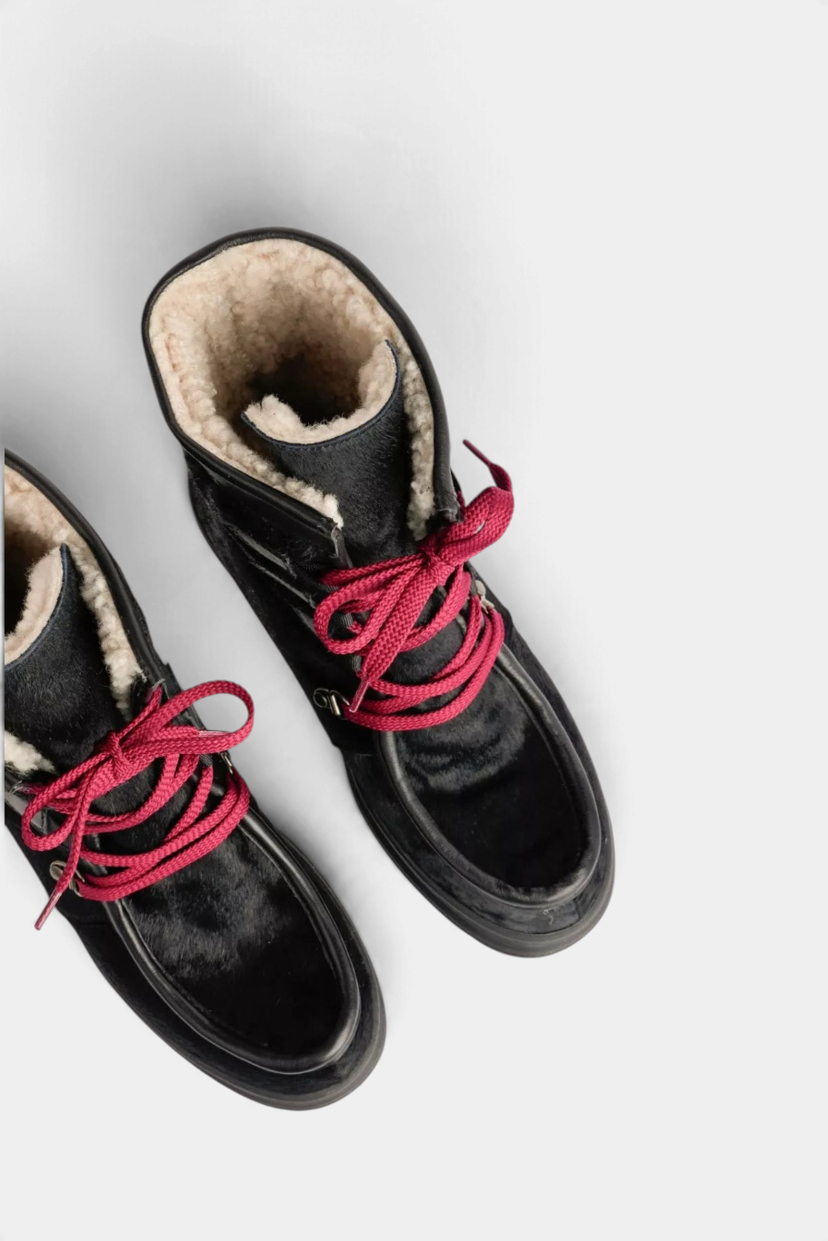 The Copper Shed Intrepid Pony Boot in black cowhide with shearling lining and vibrant red laces.