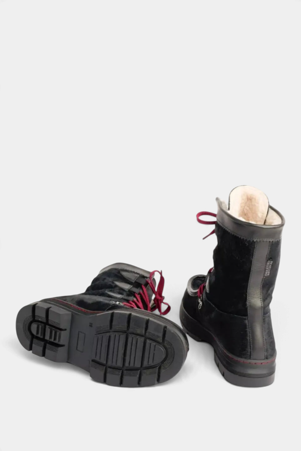The Copper Shed Intrepid Pony Boot in black cowhide with shearling lining, rubber sole, and red laces.