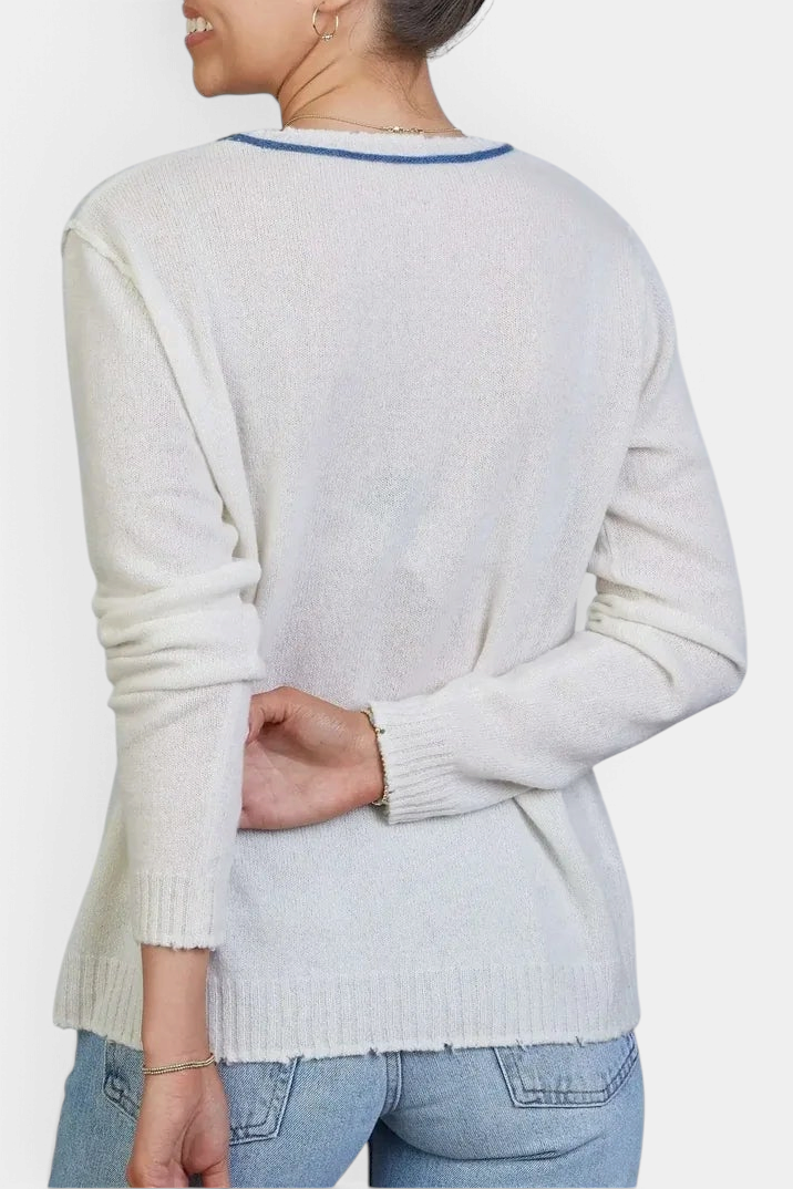 The Copper Shed ivory Mongolian cashmere sweater with raw-edge hem and blue contrast neckline worn by a woman.