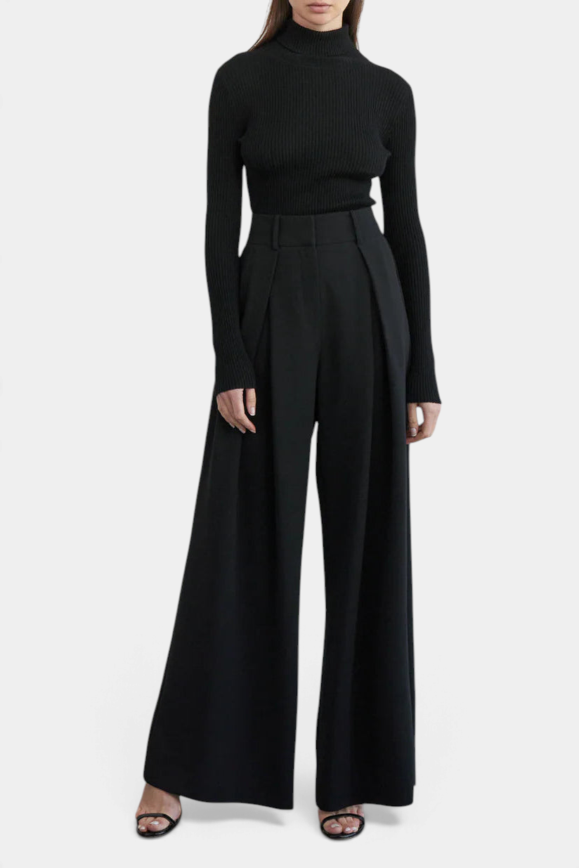 The Copper Shed black ribbed turtleneck sweater with long sleeves worn with wide-leg trousers