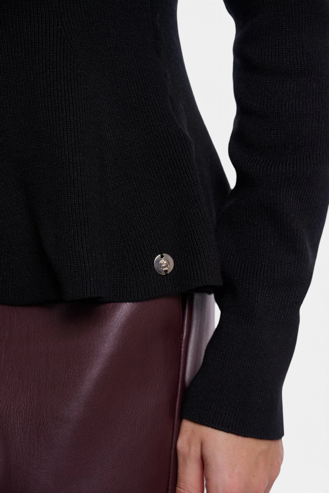 The Copper Shed Jelilah black viscose-blend knit peplum sweater featuring a small silver logo detail at the hem.