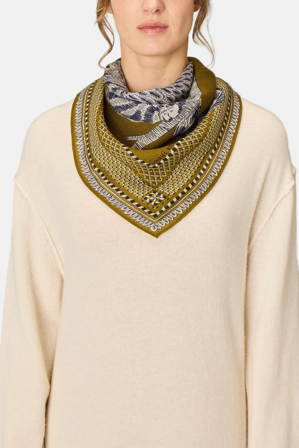 The Copper Shed Square 70 Chouette khaki wool scarf with intricate patterned border worn by a model