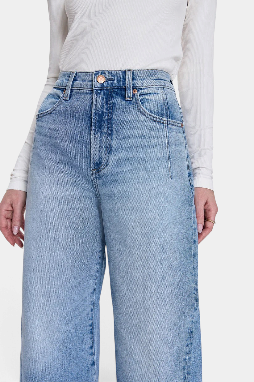 The Copper Shed Kyra high rise jeans in a light vintage wash with a bowed leg silhouette and front seam detailing.