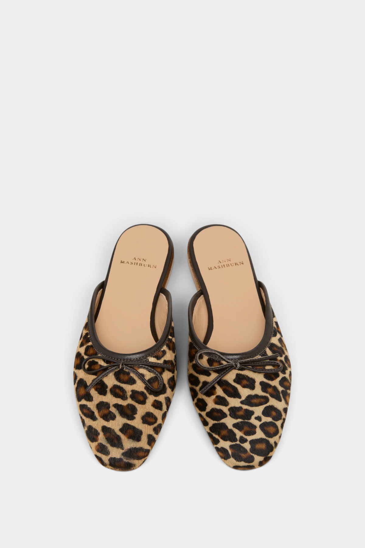 The Copper Shed Joy Mule in leopard print calf hair with a leather bow and almond toe, top-down view.