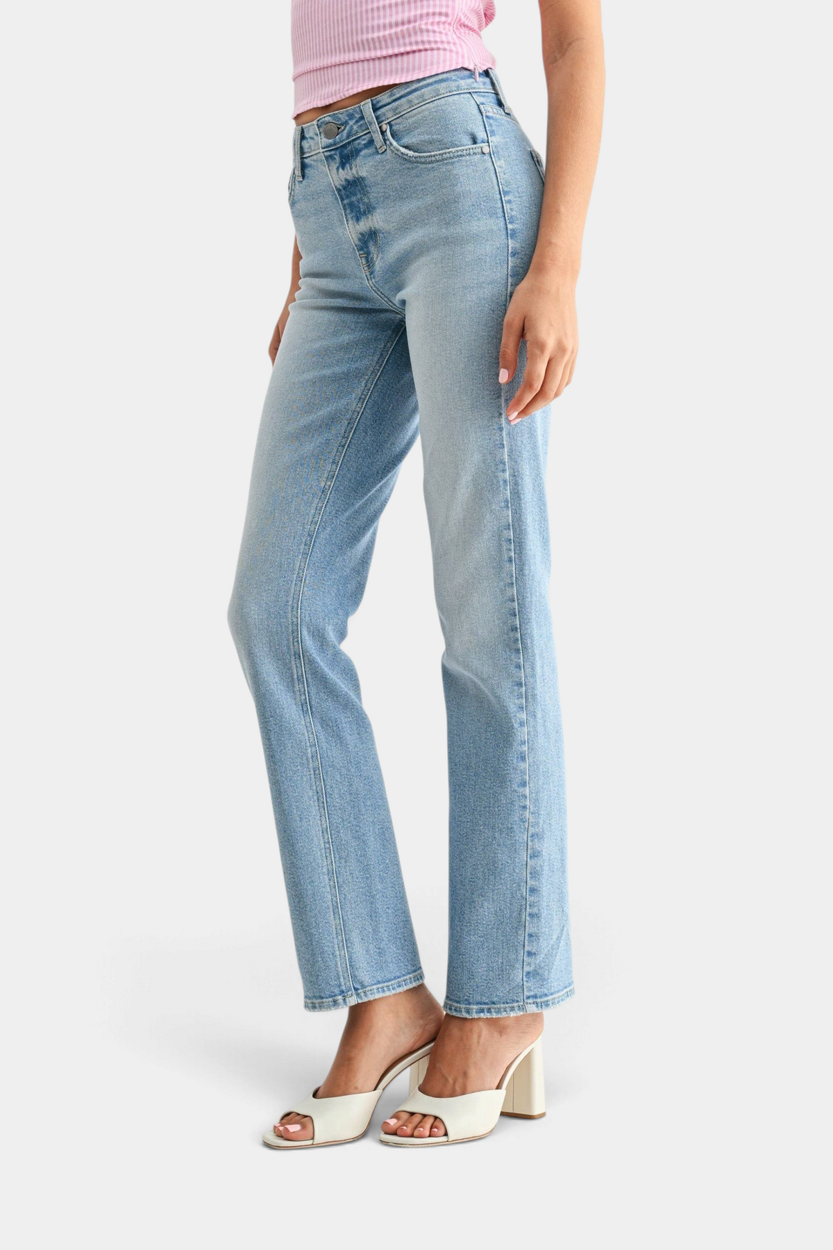 The Copper Shed mid-rise stovepipe straight leg jeans in light wash denim worn with white heeled sandals