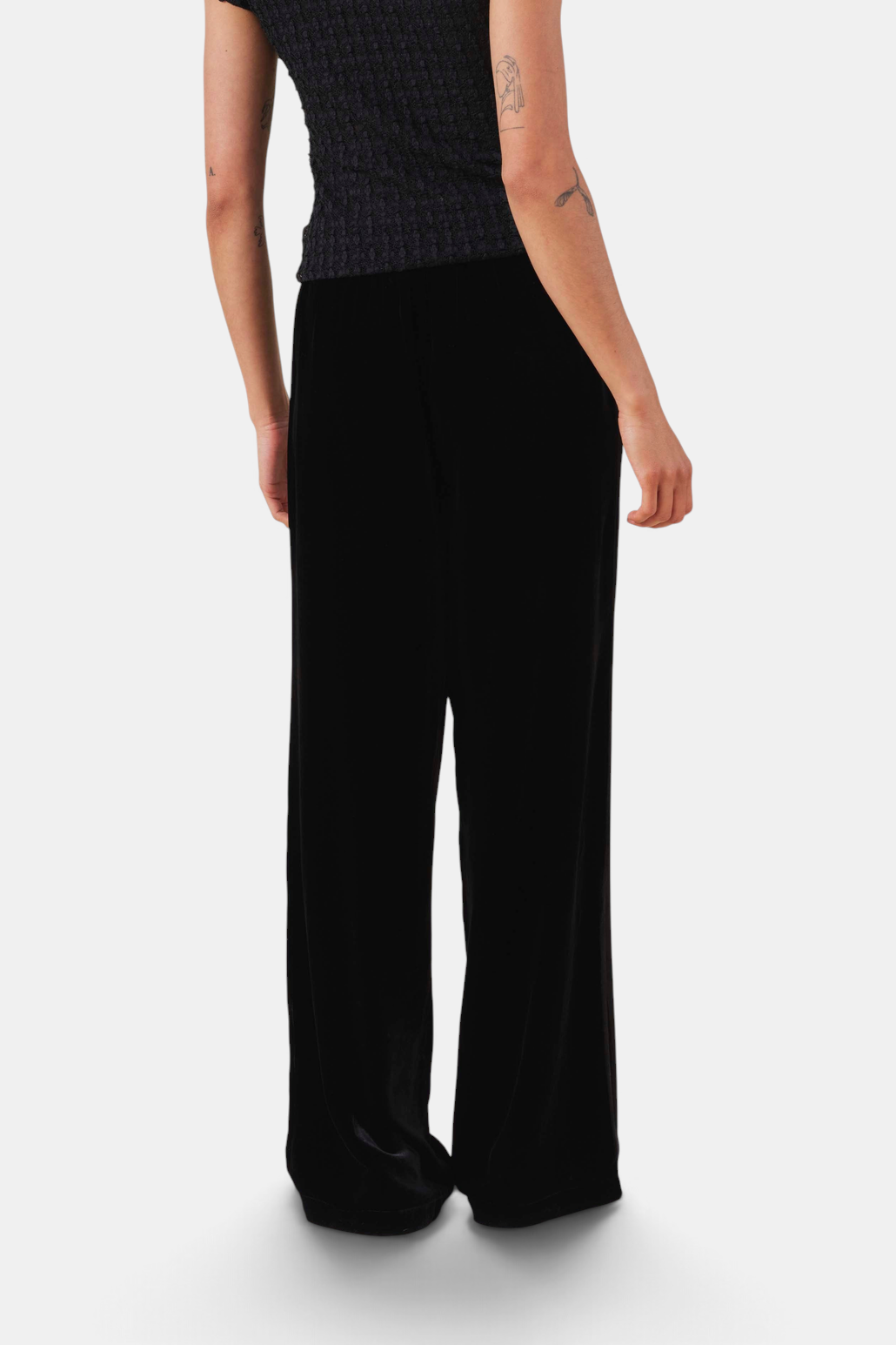 The Copper Shed Lily black velvet flared trousers with a high-rise fit and soft silk-viscose blend texture.