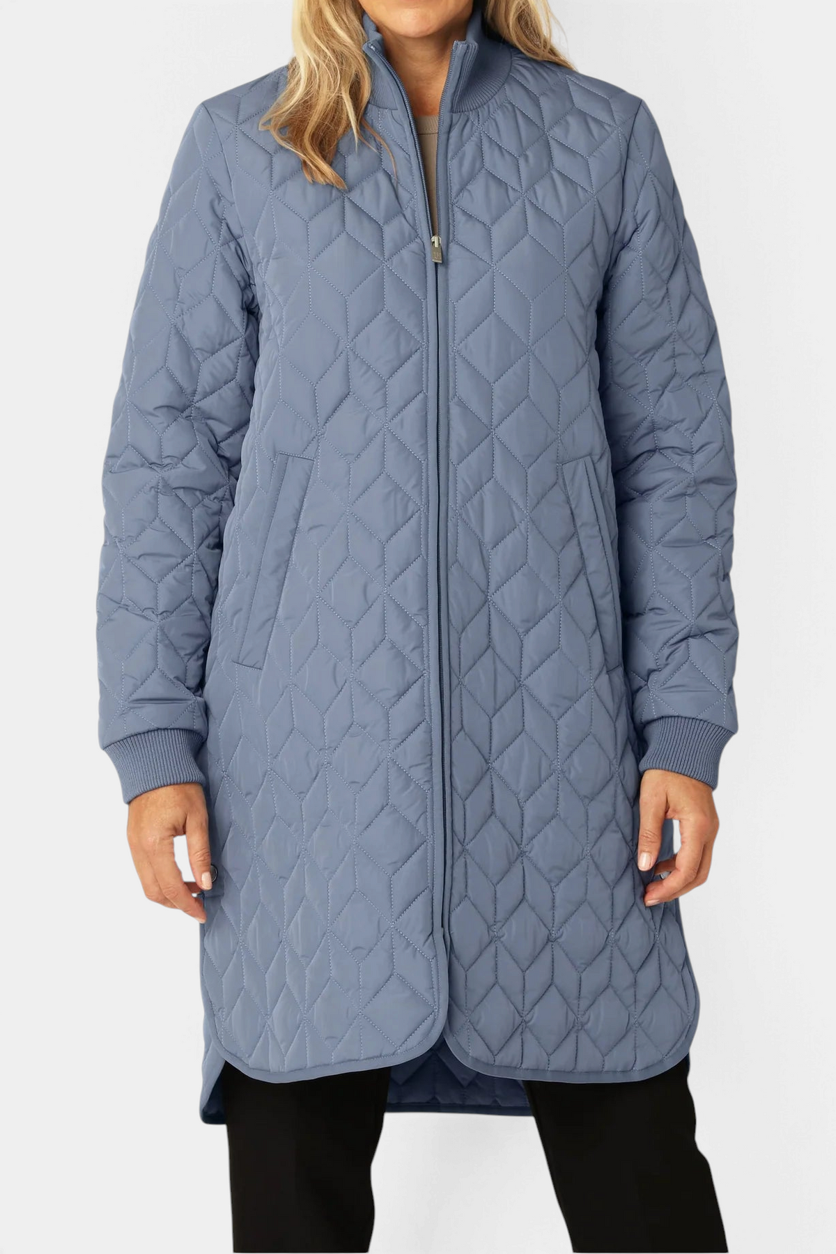 The Copper Shed long blue padded quilt jacket with a high ribbed neckline and 2-way zipper on a model