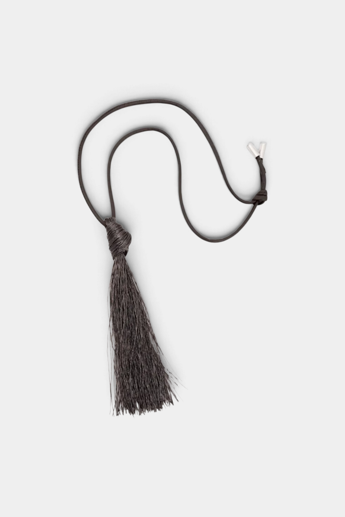 The Copper Shed long necklace featuring a dark leather cord and a long, dark viscose blend fringe tassel pendant.