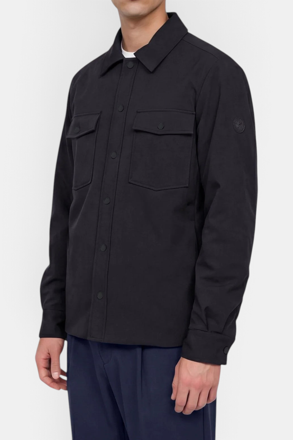 The Copper Shed men's black German jacket featuring patch pockets, snap-button closures, and a clean modern aesthetic.
