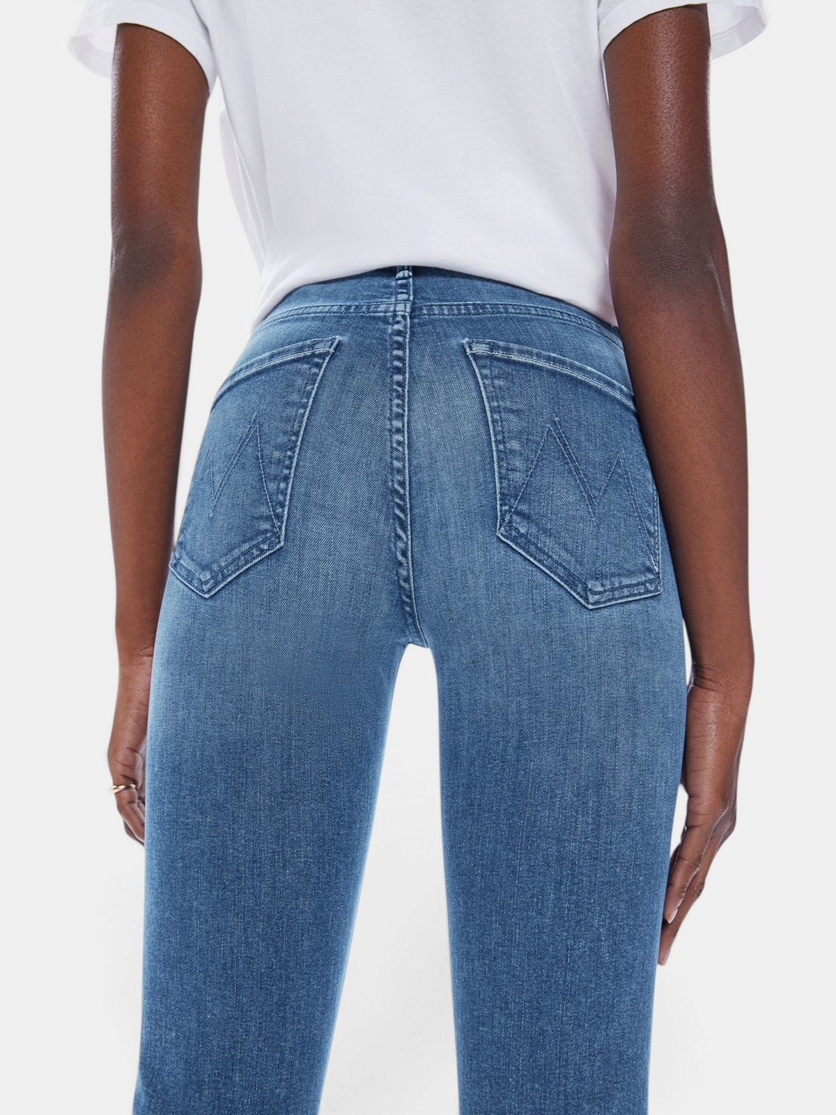 The Copper Shed Mid Rise Dazzler Ankle jeans in blue denim with back pocket detail worn by a model