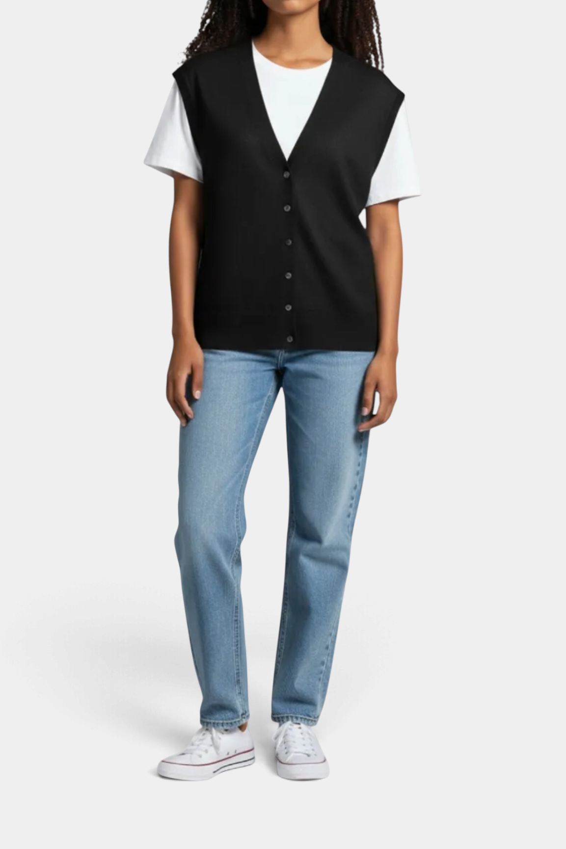 The Copper Shed Millie black merino wool button-front vest layered over a white t-shirt and blue jeans
