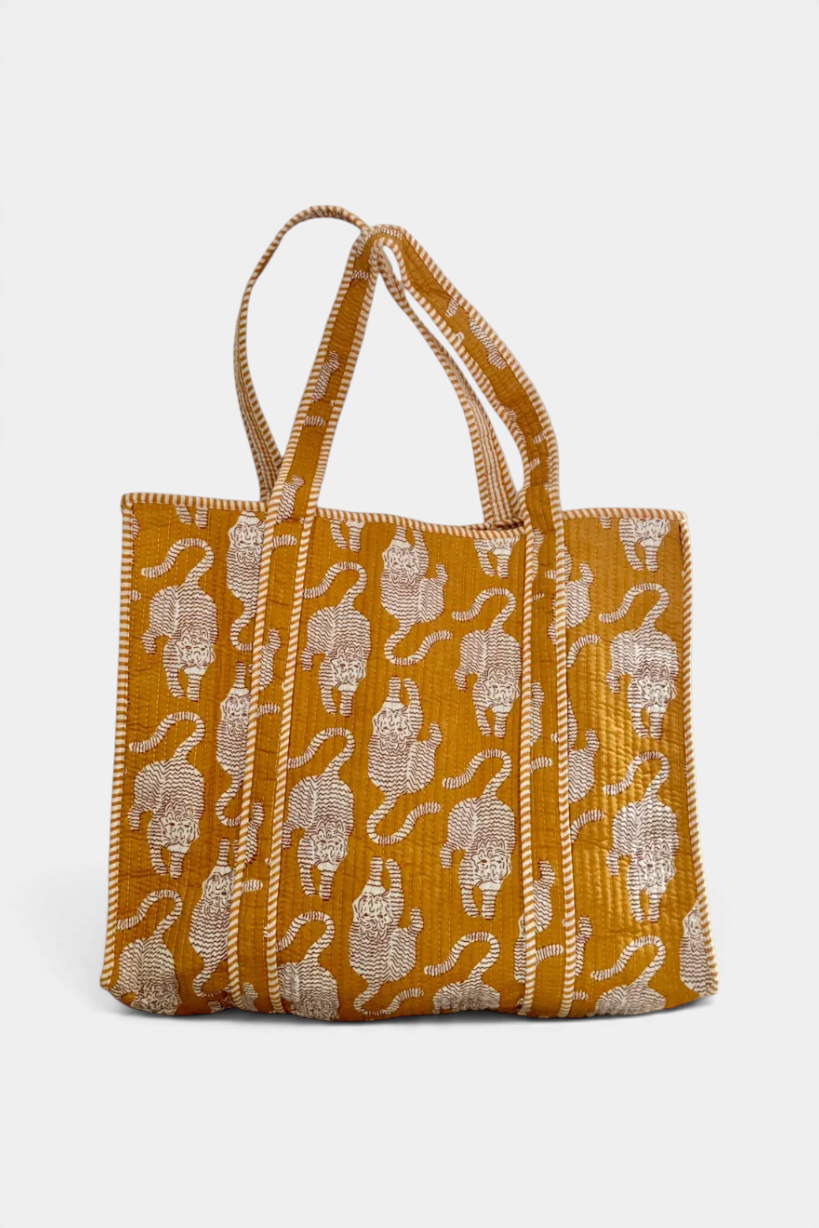 The Copper Shed quilted cotton tote bag in mustard yellow with a white tiger block print pattern and striped handles.