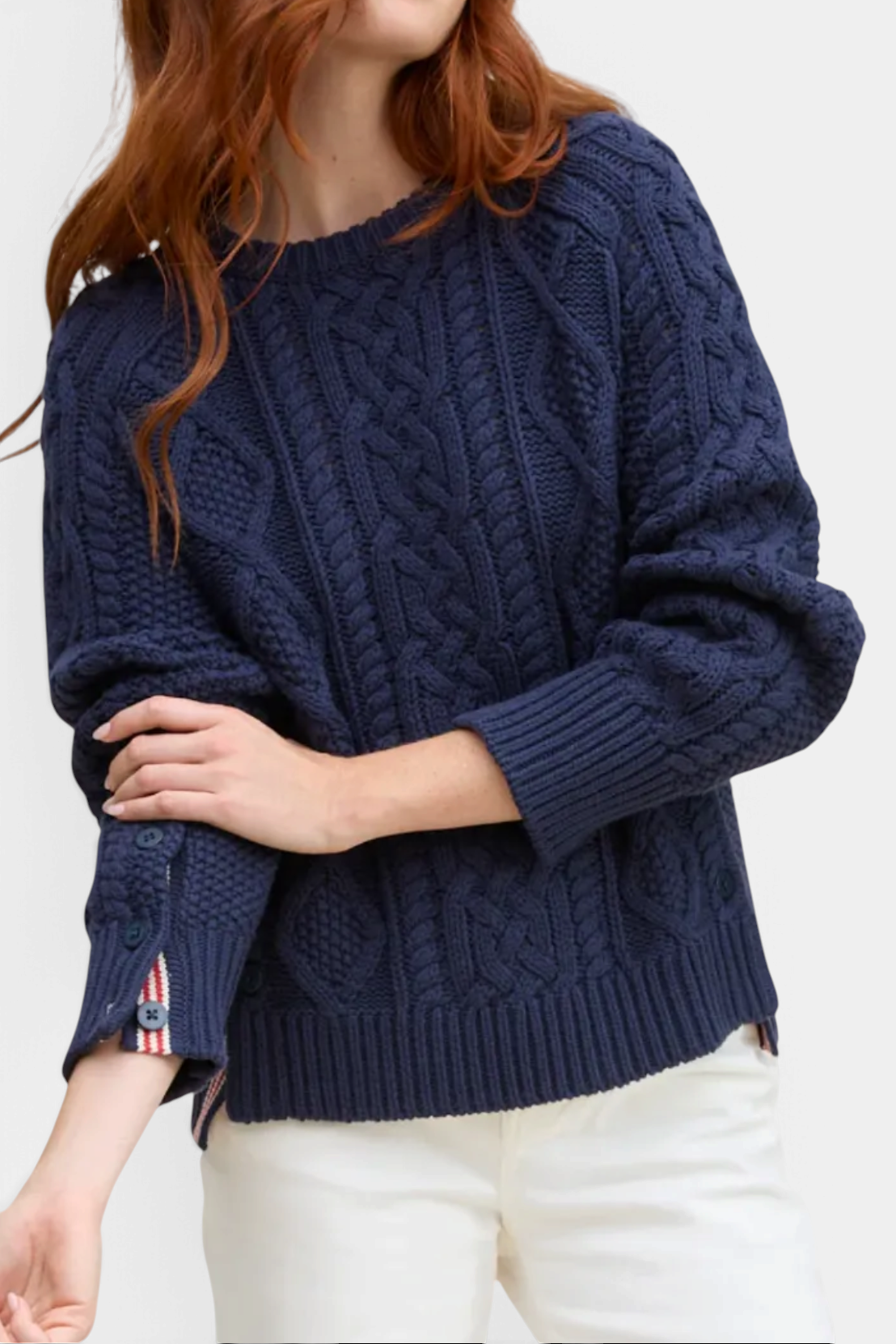 The Copper Shed navy blue cable knit pullover with striped ribbon inset and buttoned cuffs on a model
