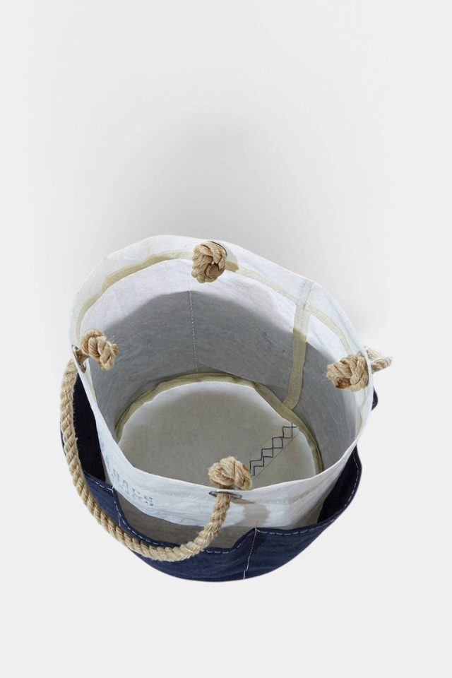 The Copper Shed navy canvas tool bucket bag with six exterior pockets and sturdy hemp rope handles, top-down view.