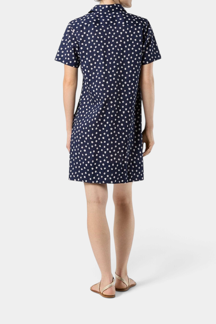 Back view of The Copper Shed navy blue crinkle cotton short-sleeved popover dress with a white daisy floral print.