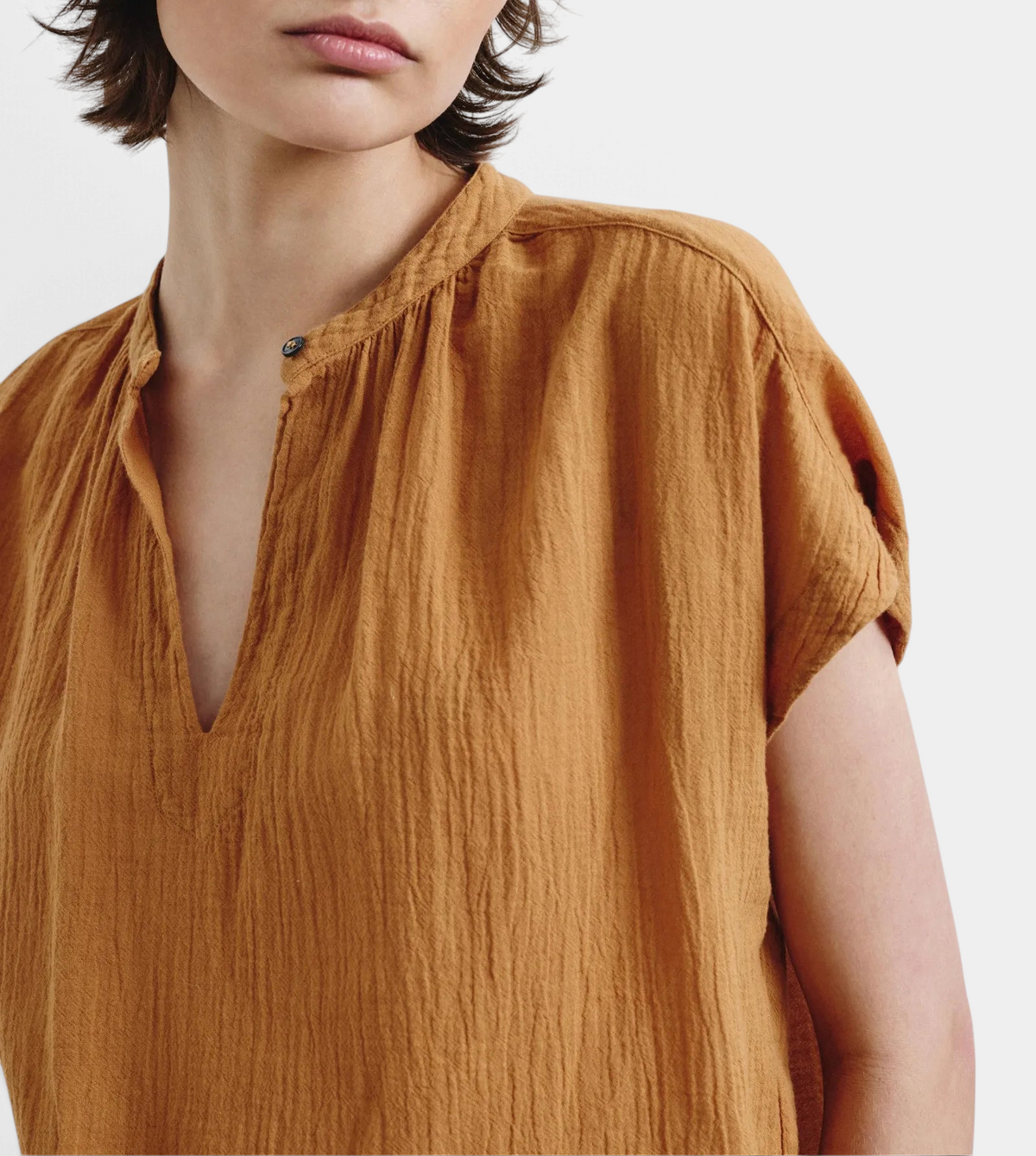 The Copper Shed organic cotton crepe gauze top in mustard yellow with a split neckline and short sleeves.