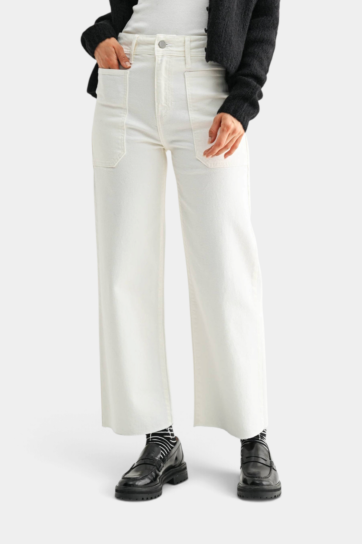 The Copper Shed off-white high rise utility wide leg jeans with large front pockets worn with a black cardigan.