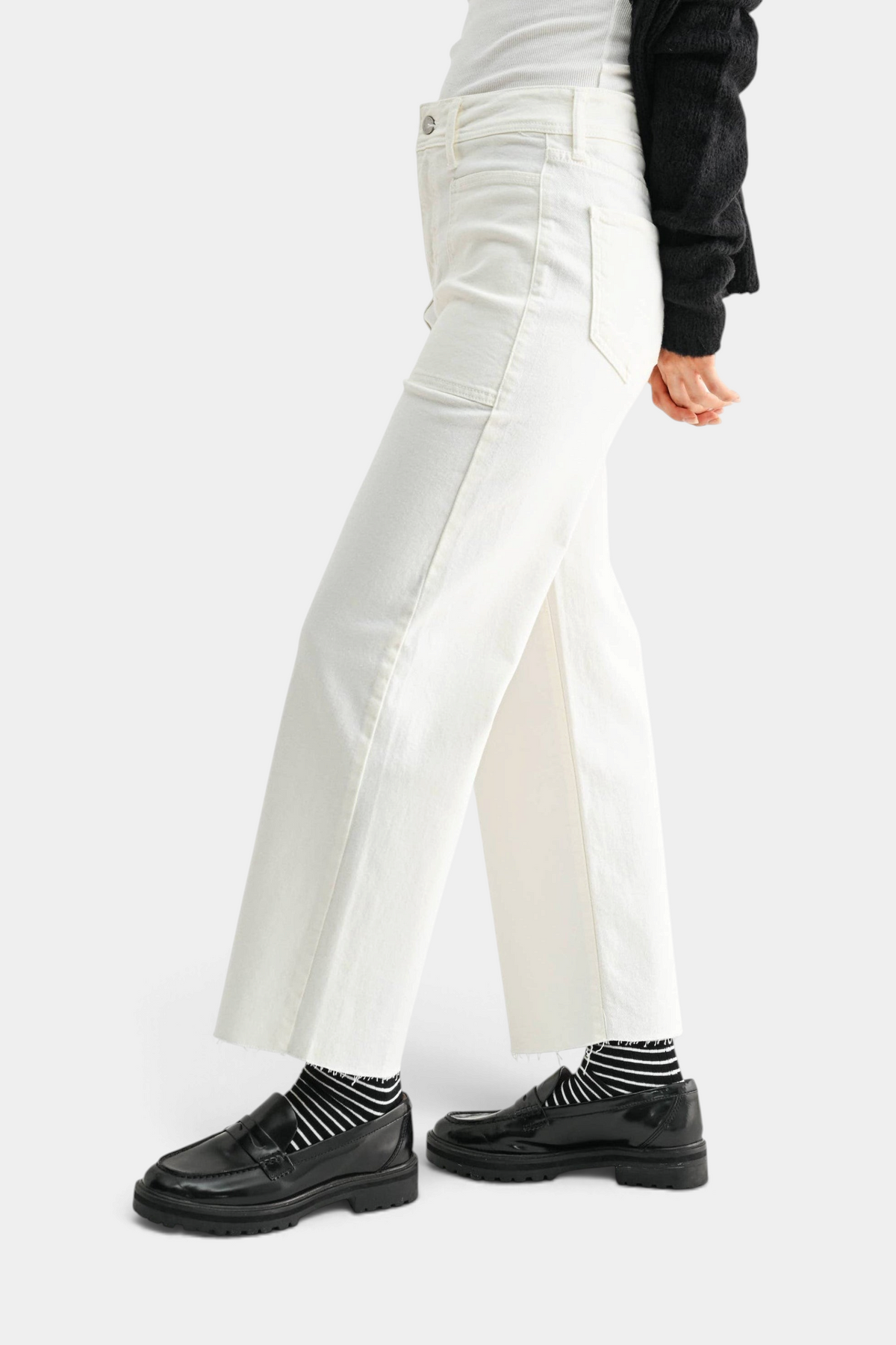 The Copper Shed high rise off-white wide leg utility jeans with large pockets and raw hem, side profile view.