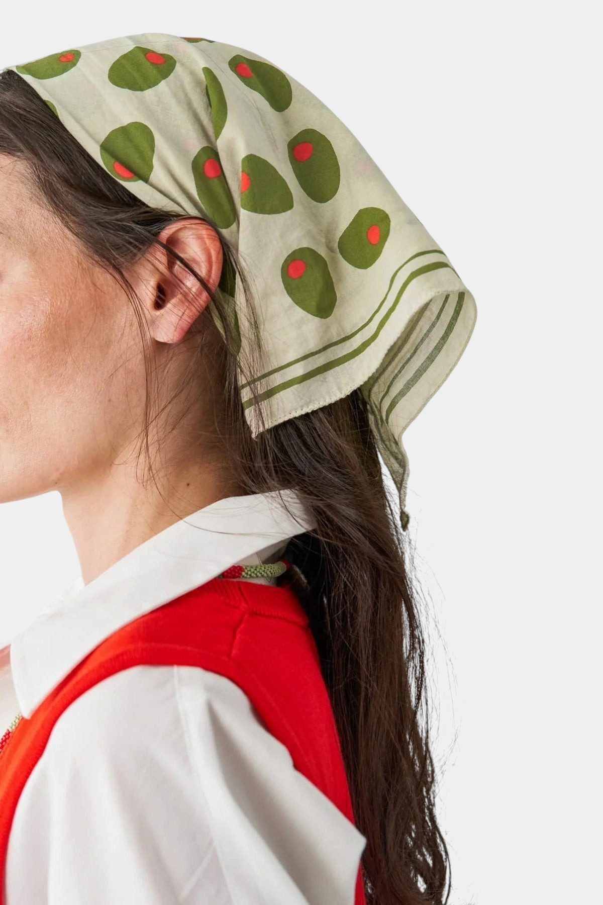 The Copper Shed Carson olive print cotton scarf tied as a headscarf featuring green olives with red pimentos
