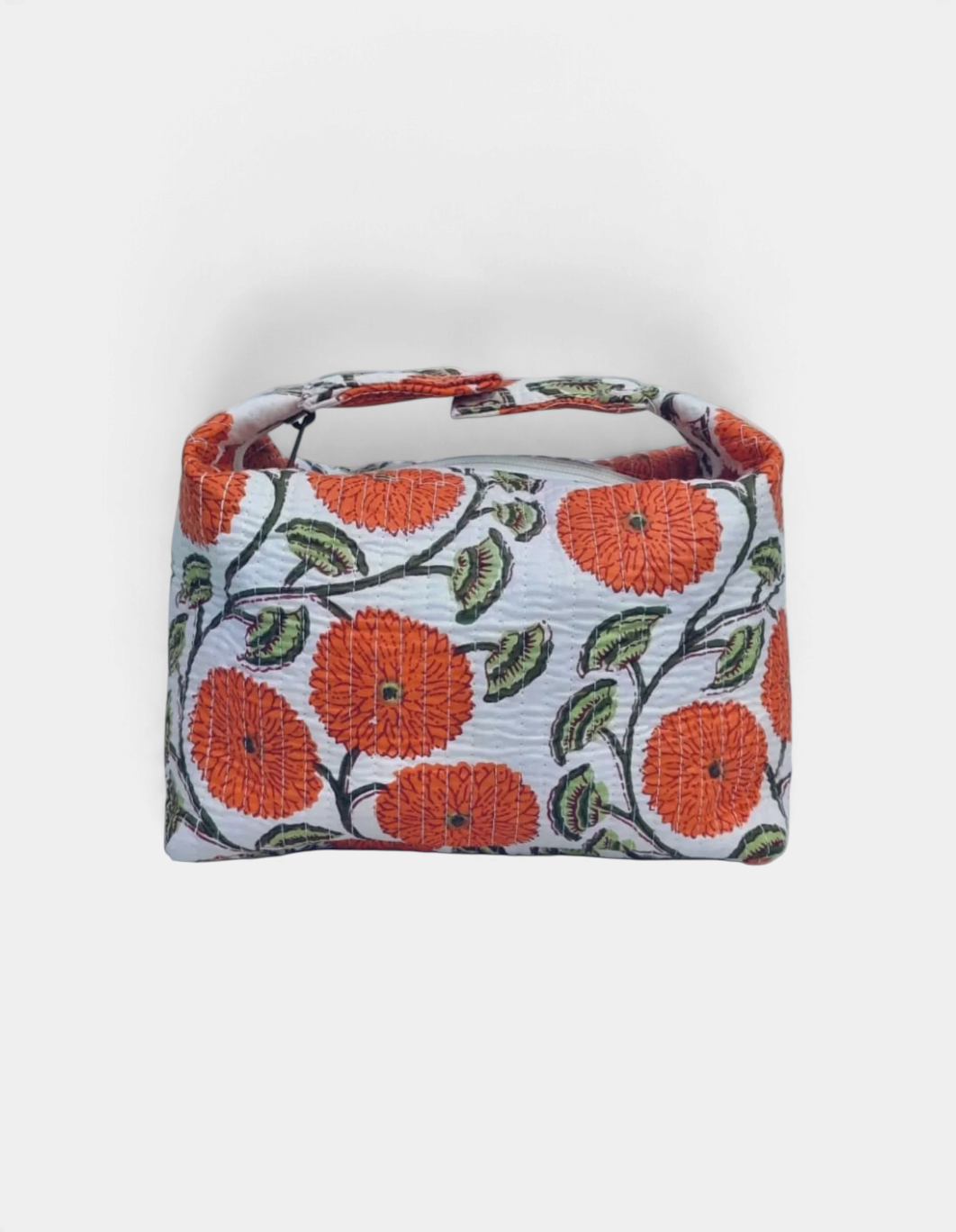 The Copper Shed quilted makeup bag in white with orange floral Indian block print and adjustable snap strap.