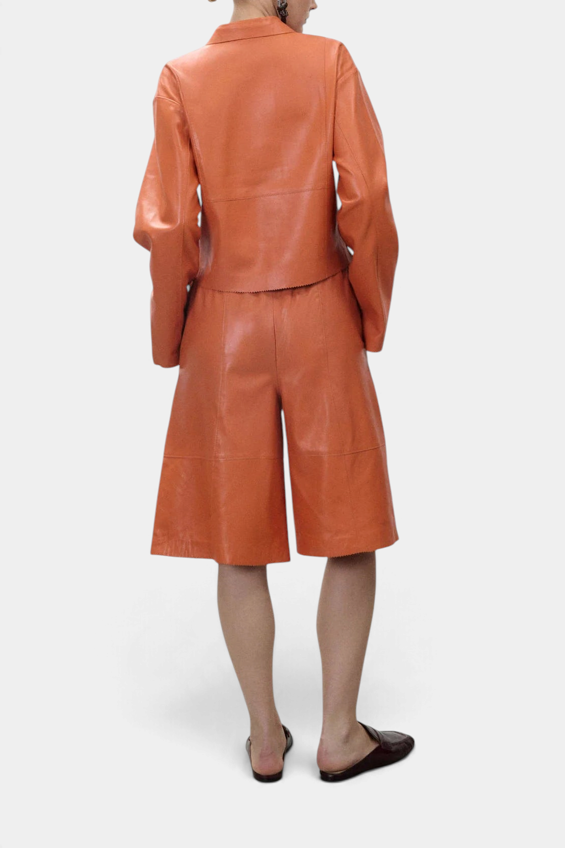 The Copper Shed orange genuine leather short jacket and matching leather shorts, back view on a model.