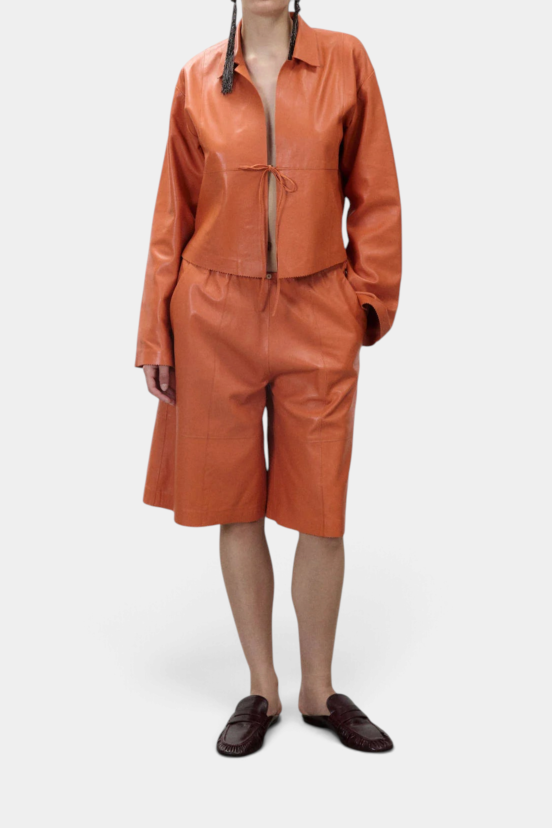 The Copper Shed orange genuine leather short jacket with flared sleeves, classic collar, and drawstring fastening.