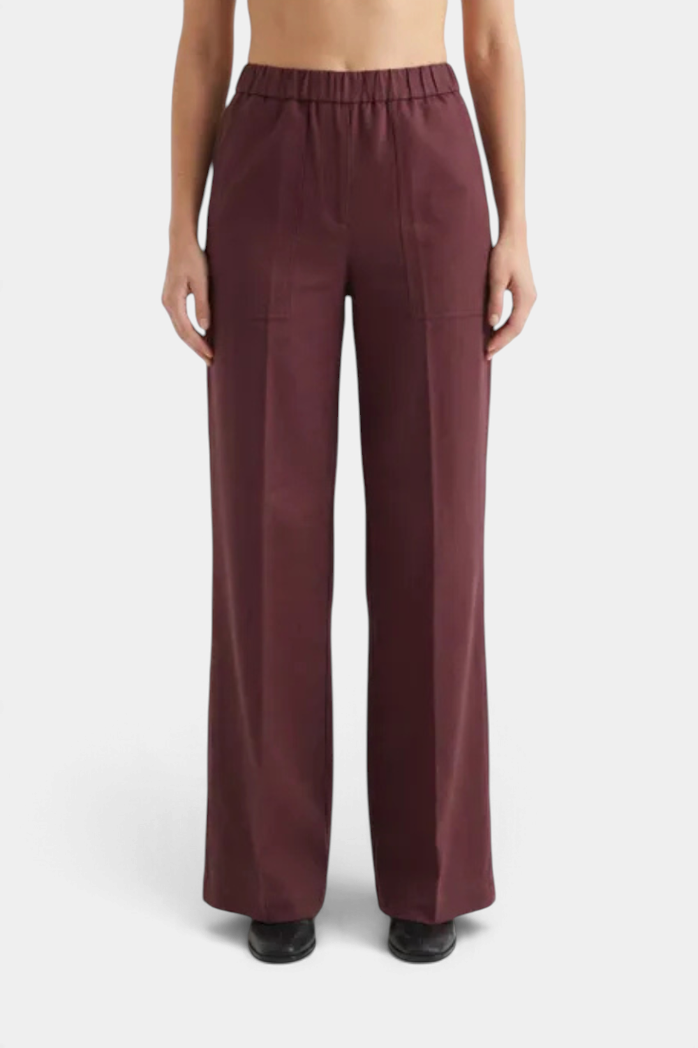 The Copper Shed Perillo linen pants in eggplant featuring an elastic waistband and wide-leg silhouette.